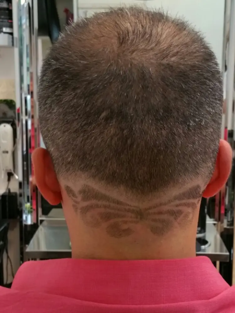 Close-up of a patterned hair design razored into the back of a short cut
